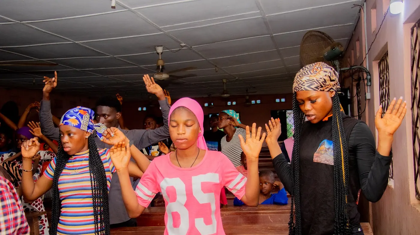 Young believers lifting their hands in worship during a service in Aiyepe, Ijebu