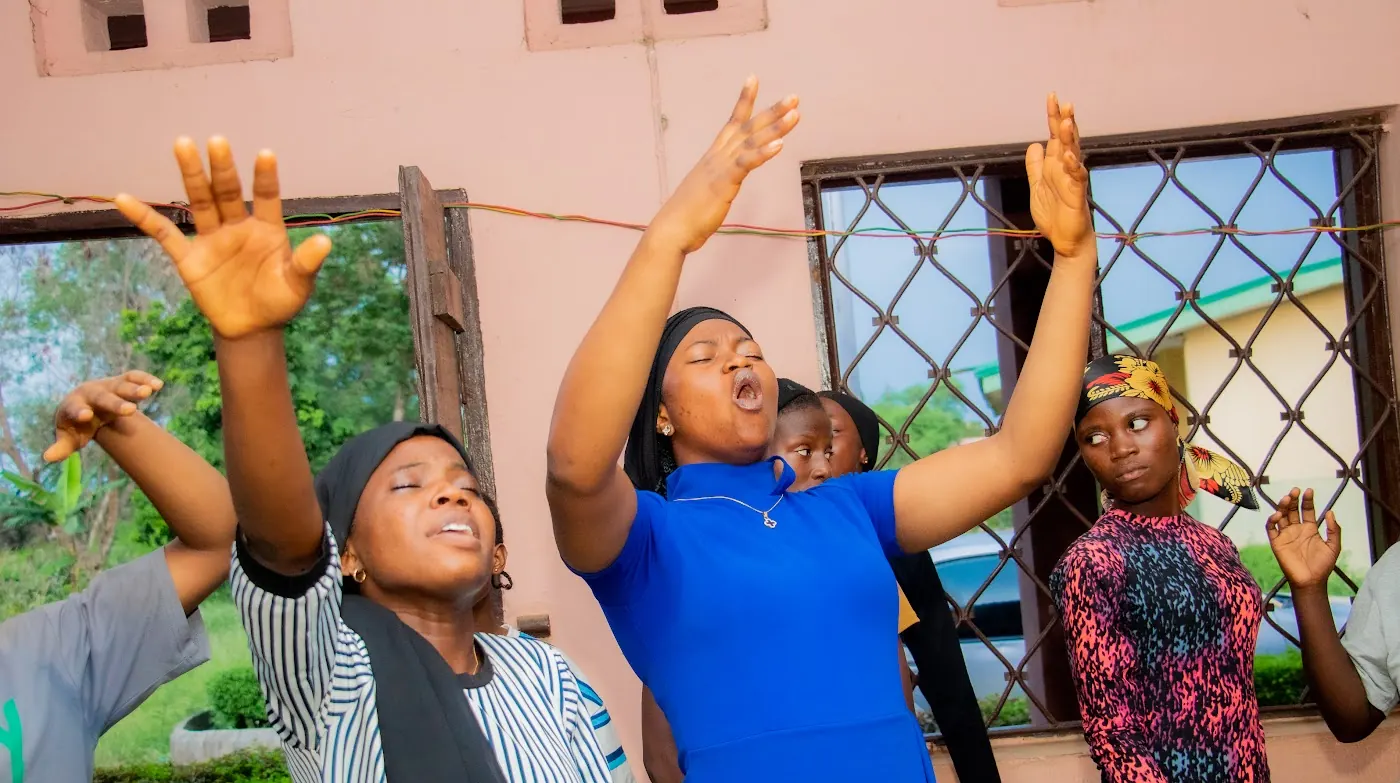 Worshippers lifting their hands in praise during a service at Adoration New Life Ministry
