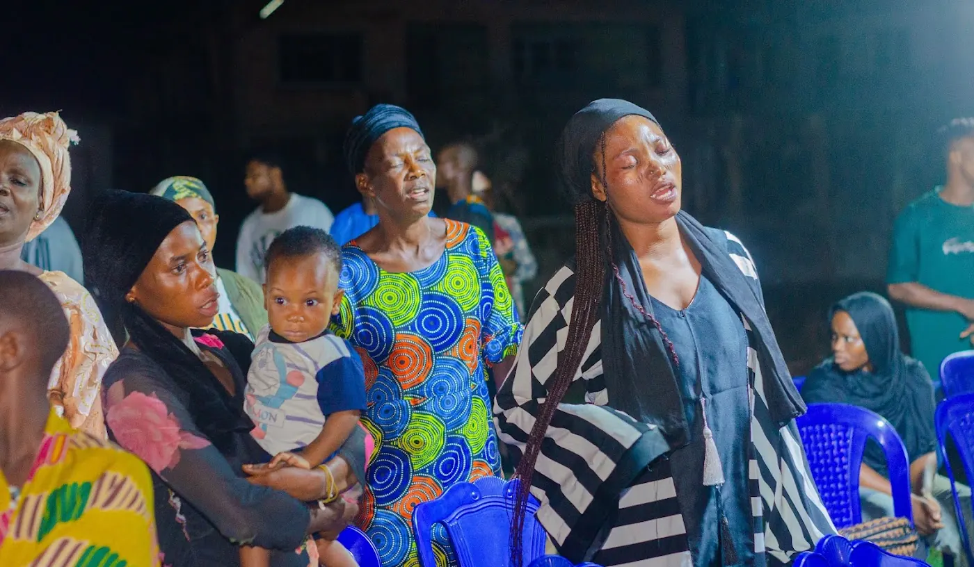 Worshippers praying outdoors at night during a vigil at Adoration New Life Ministry, Aiyepe